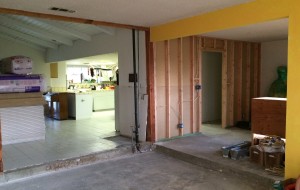 The wall separating the old family room and sunken living room has been mostly removed and a soundproof new wall added on right.