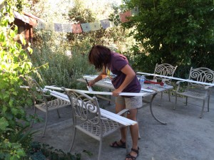 Chandramani paints baseboards in the garden.