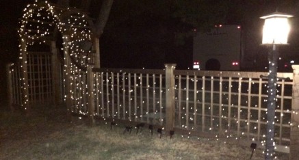 The arbor and fence with lights.
