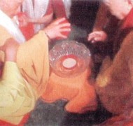 Dharma Master Wu Ming removes the lid from the nectar bowl as others look on.