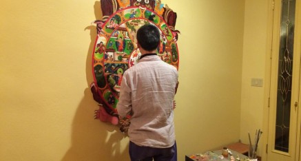 The artist, Ci Guan, adds finishing touches to his painting after installing it in the entry way to the temple.