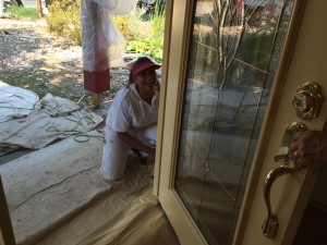 Claudia finishes painting the outside of the front door.