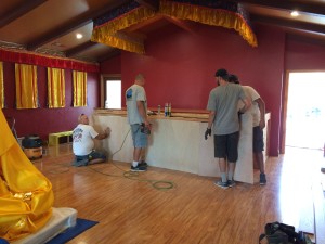 Charlie and his crew install the oak veneer to the altar.